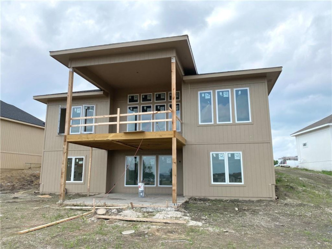 Rear view of home featuring a covered main level deck an lower level balcony