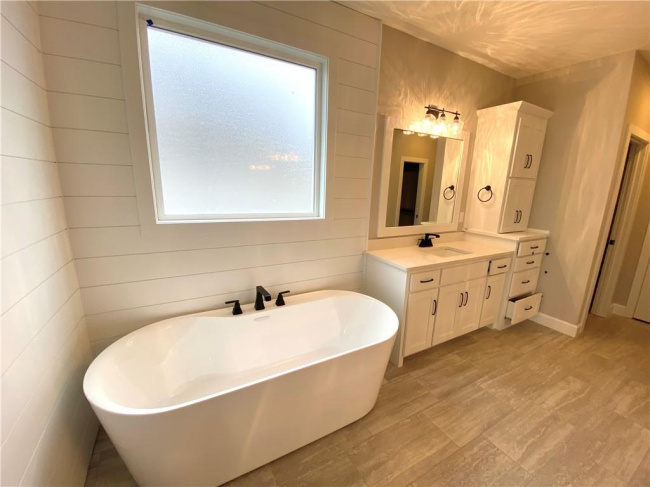 Bathroom with a tub, vanity, and tile floors